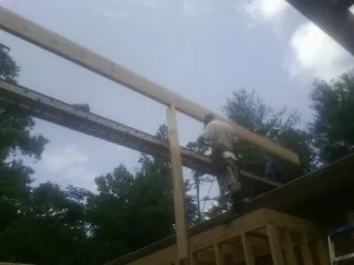 Carpenter setting a ridge beam over a new addition frame — Ice Dam Removal by Roofing Brothers in San Gregorio